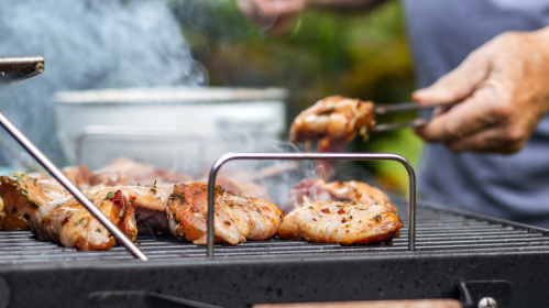 Mann grillt Fleisch