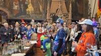 Bunt verkleidete Menschen feiern in historischem Saal